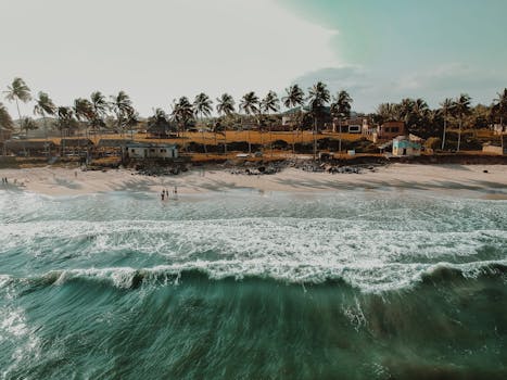 Stunning aerial view of a tropical beach with palm trees in Accra, Ghana, during sunset.